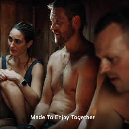 Three people sitting inside the 4-Person Outdoor Traditional Cedar Sauna