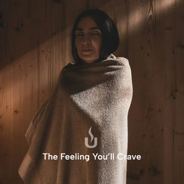 Woman wrapped in a towel after a session in the 4-Person Outdoor Traditional Cedar Sauna