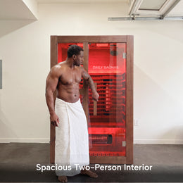 Man in a towel stepping out of the 2-Person Red Light + Full Spectrum Cedar Sauna