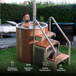 Man in the 1-Person Cedar Ice Bath with Chiller on a backyard lawn, feature icons