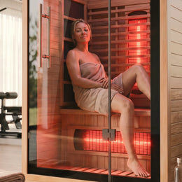 Woman in a towel sitting inside the 1-Person Full Spectrum Hemlock Sauna